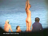 The naked girl is staying on the nudism beach having no idea about the camera spying her!
